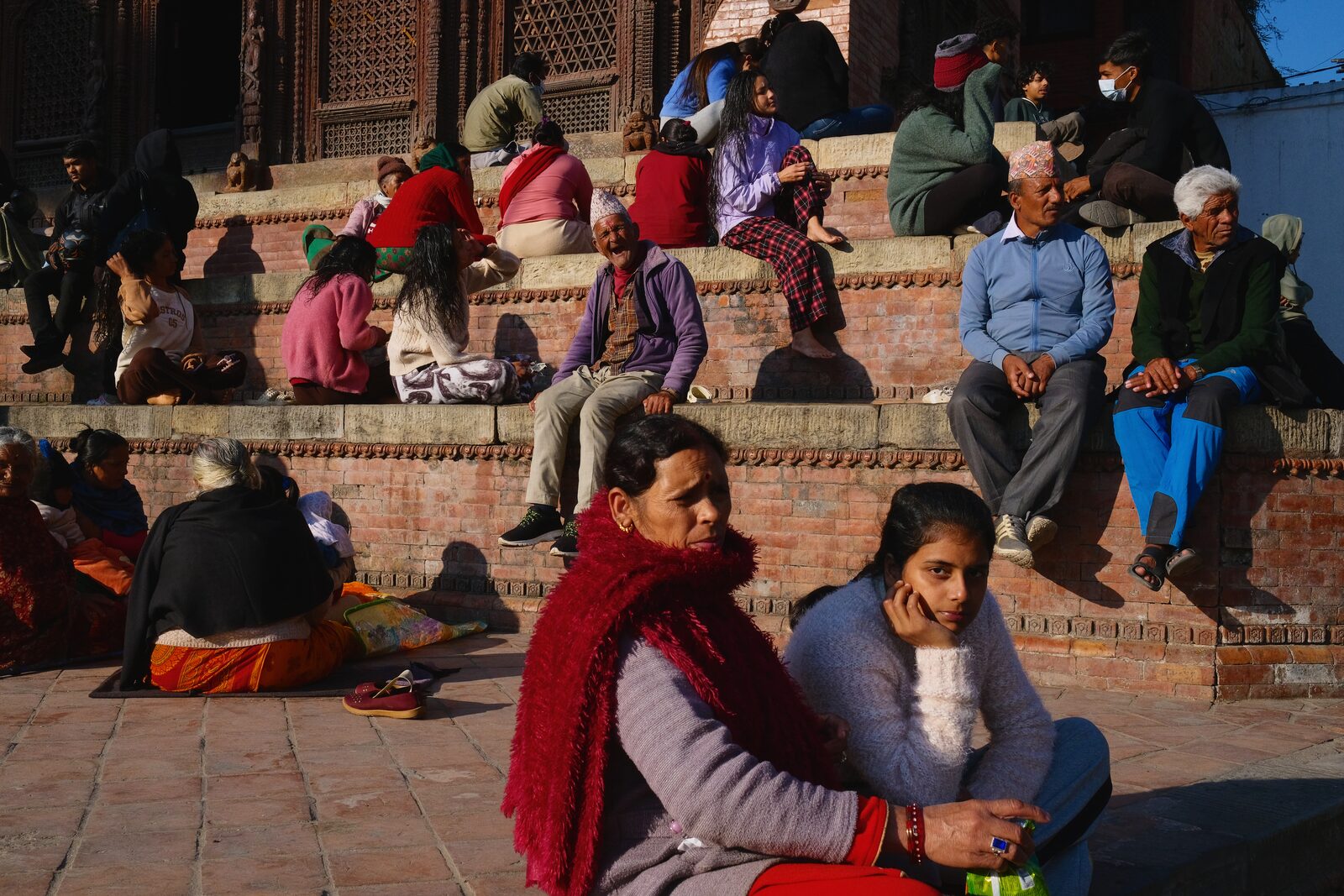 Women in red shawls sitting on temple steps in Nepal — Angelo for ZELZAL