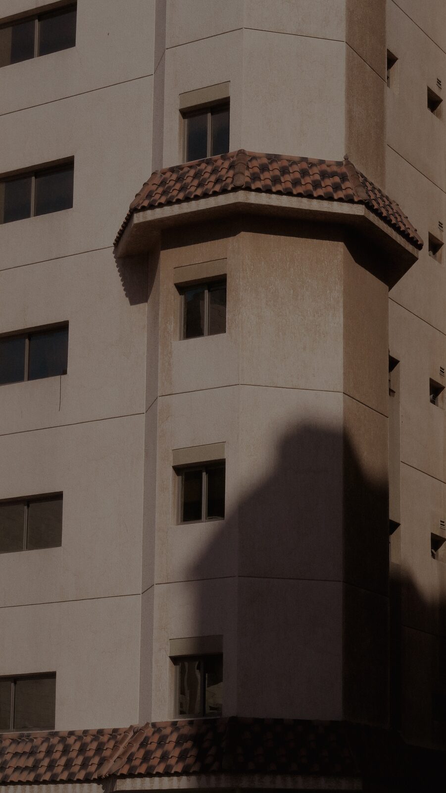 Beige building with a tiled bay in late shade — Bashar Belal for ZELZAL