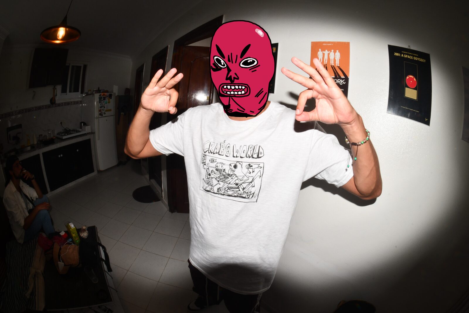 Person in a red monster mask making hand signs, flash-lit — Bluuecrab for ZELZAL