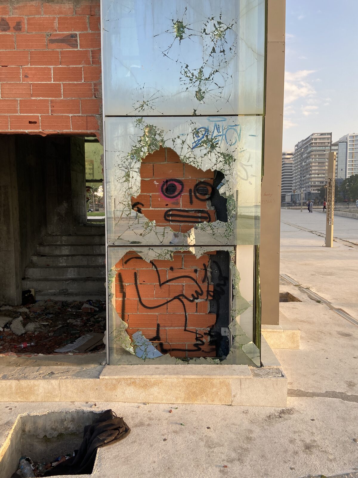 Monster face painted on a shattered glass door — Bluuecrab for ZELZAL