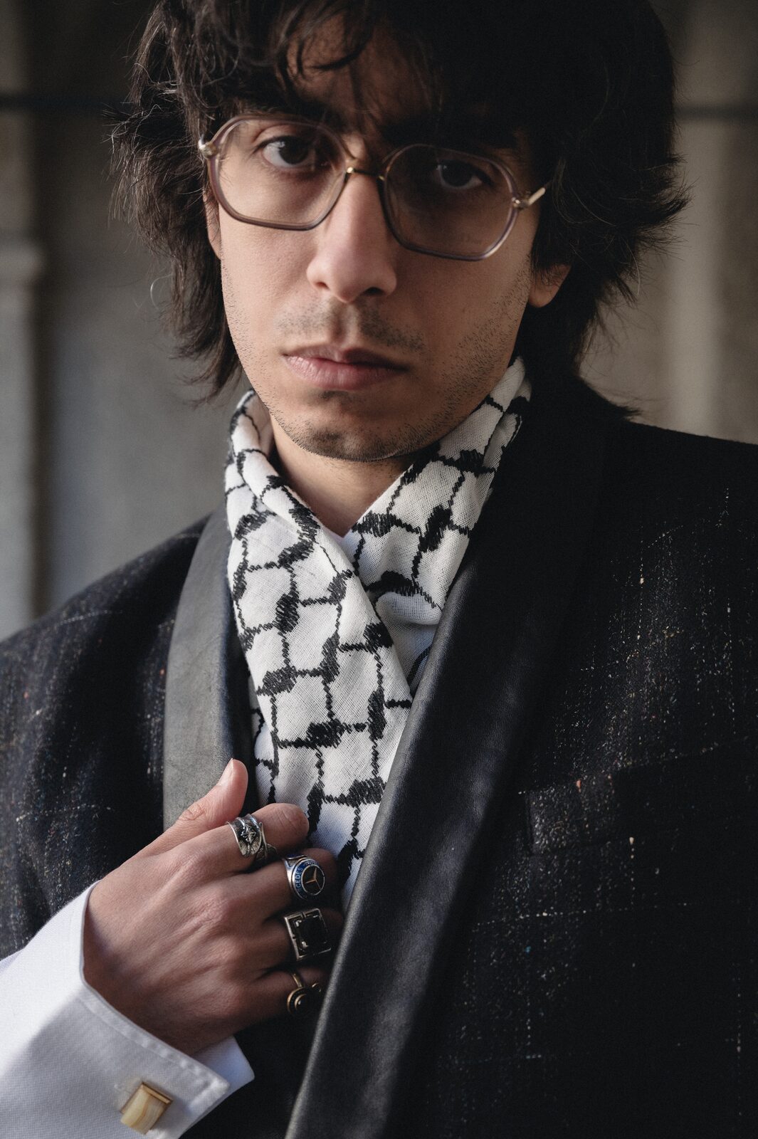 Close portrait of a young man in glasses and a keffiyeh scarf — Deza for ZELZAL