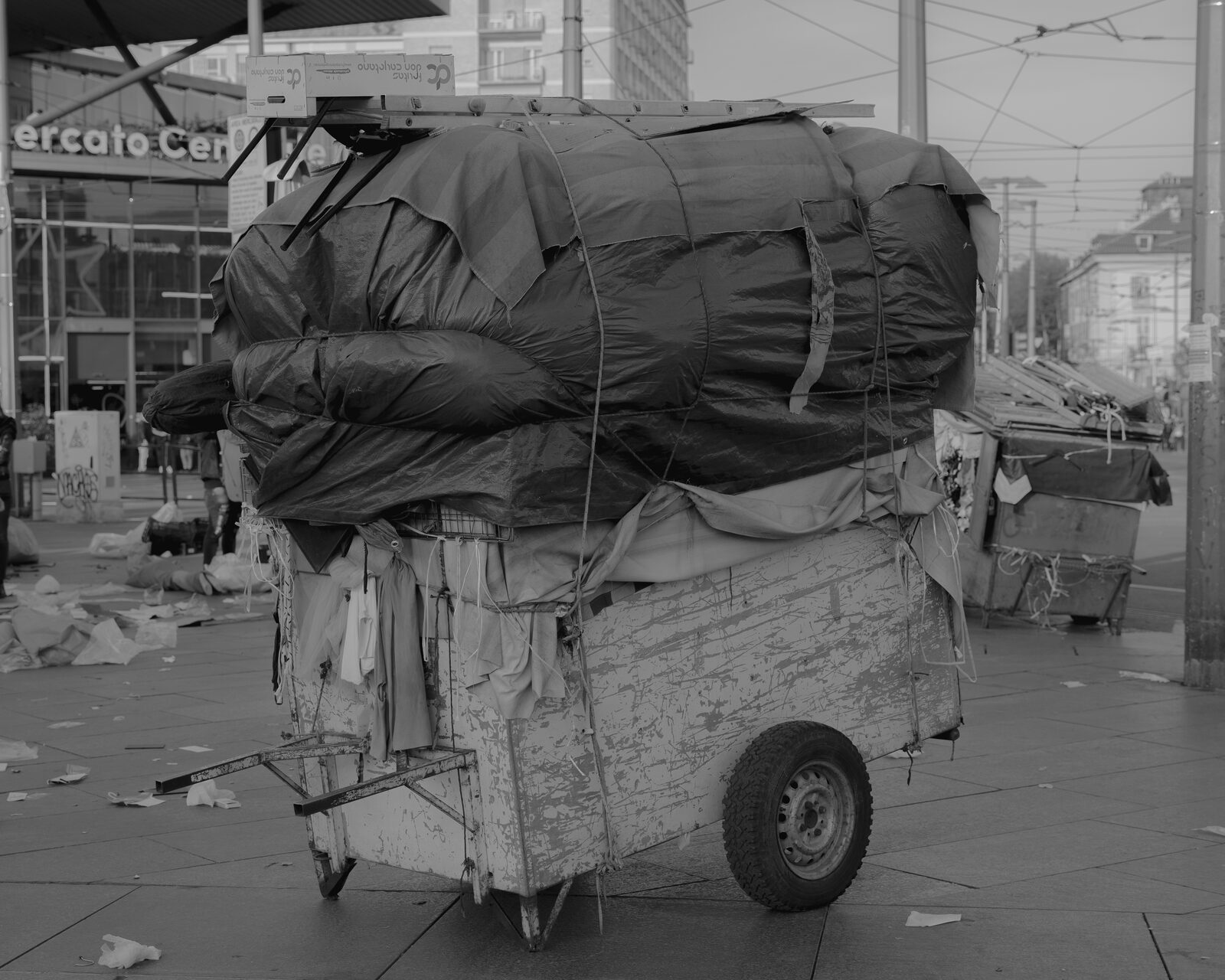 Black-and-white market trolley loaded with wrapped goods — Karim El Maktafi for ZELZAL