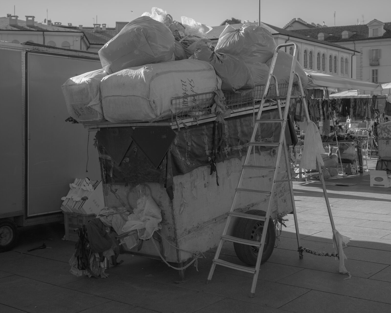 Black-and-white loaded market cart with a ladder — Karim El Maktafi for ZELZAL