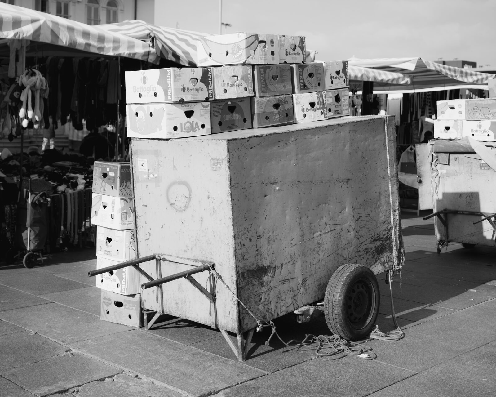 Black-and-white market cart stacked with cardboard boxes — Karim El Maktafi for ZELZAL