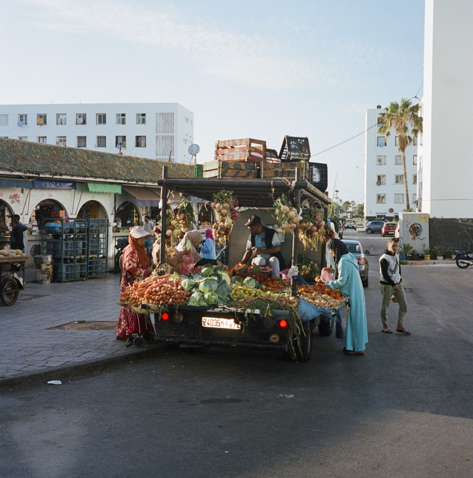 Vegetable truck surrounded by shoppers on a street — Lara Perrotte for ZELZAL