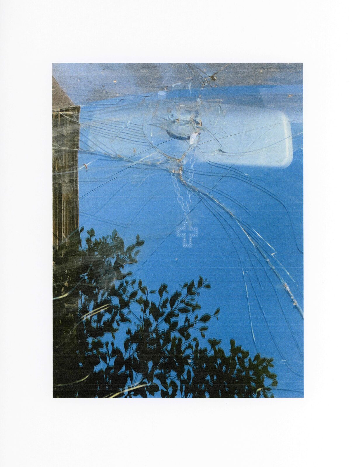 Scanned print of a cracked windscreen against blue sky and trees — Mariam El Gendy for ZELZAL