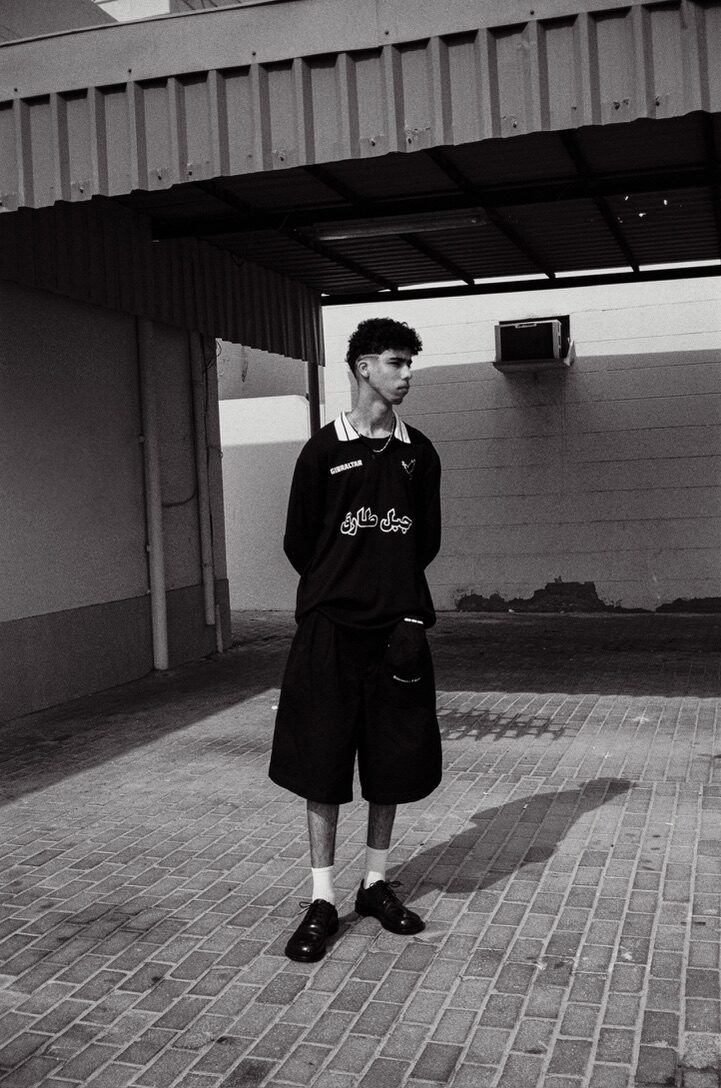 Black-and-white full-length portrait in a black jersey and shorts — Moz for ZELZAL