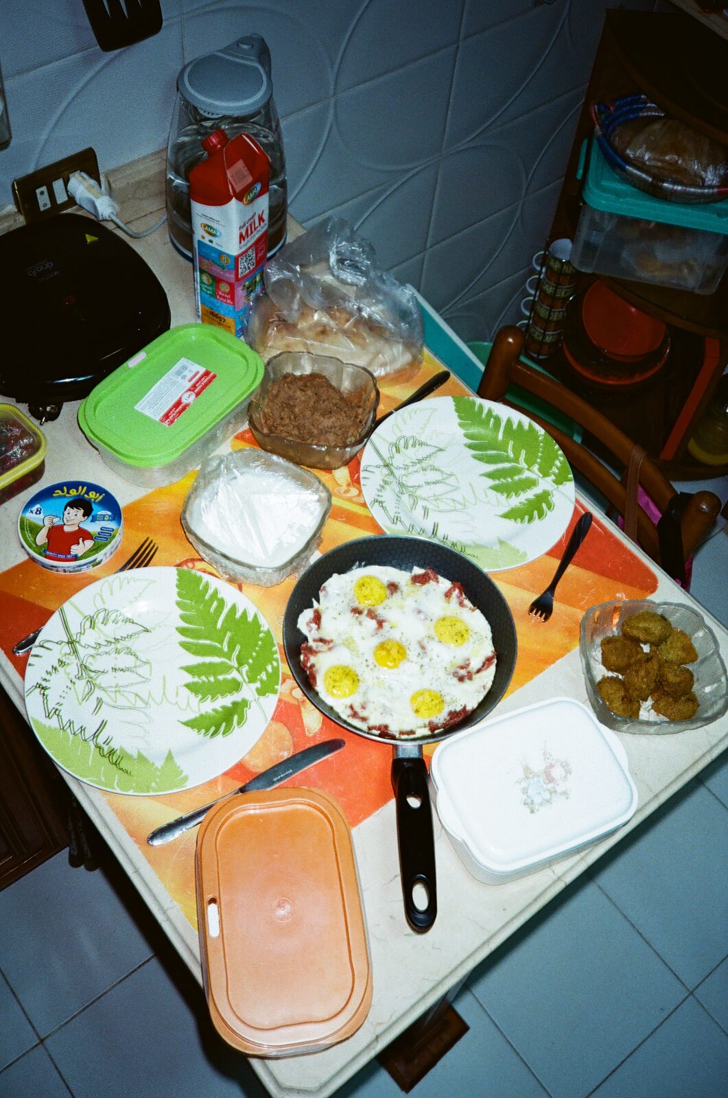 Breakfast table with eggs, bread and plates seen from above — Omar Abulata for ZELZAL