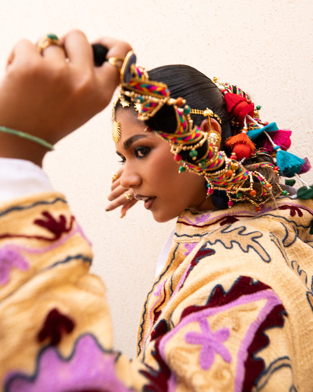 Model with an ornate braided hairpiece and embroidered jacket — Ron John for ZELZAL
