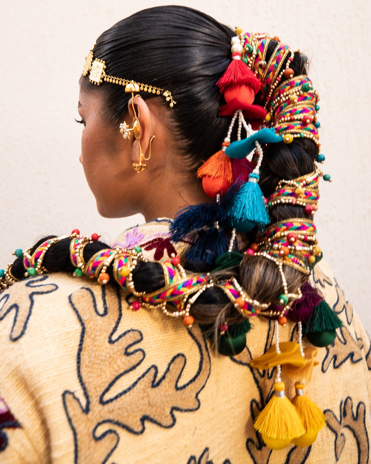 Back view of a braided hairpiece with colourful tassels — Ron John for ZELZAL