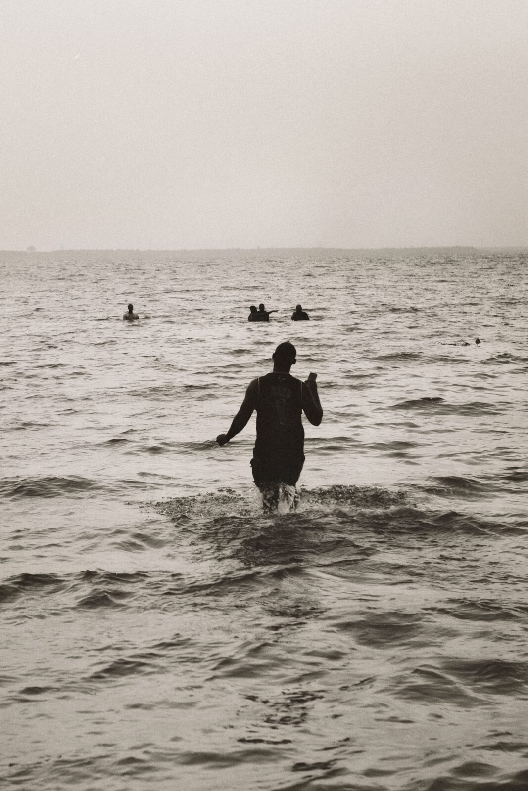 Sepia figure wading into the sea — Rosario Nandjui for ZELZAL