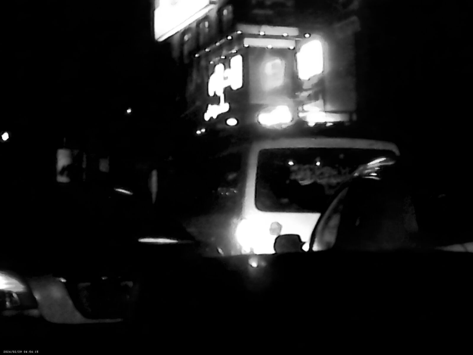 Black-and-white night traffic with glaring lights — Sadiq Y. Al-Harasi for ZELZAL