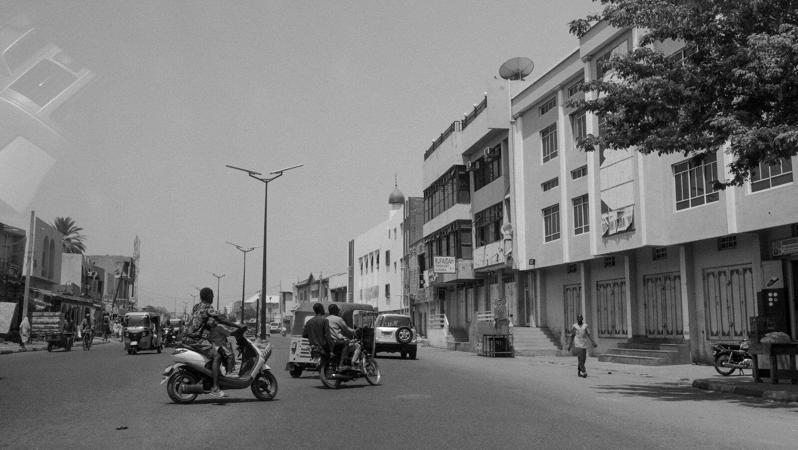 Black-and-white street with motorbikes seen from a car — Sumayah Fallatah for ZELZAL