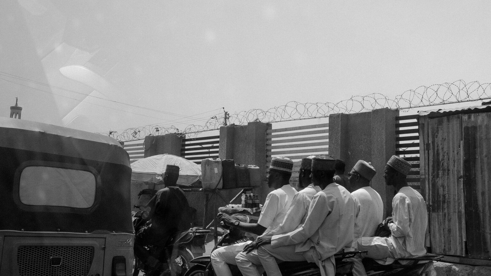 Black-and-white men on motorbikes beside a rickshaw — Sumayah Fallatah for ZELZAL