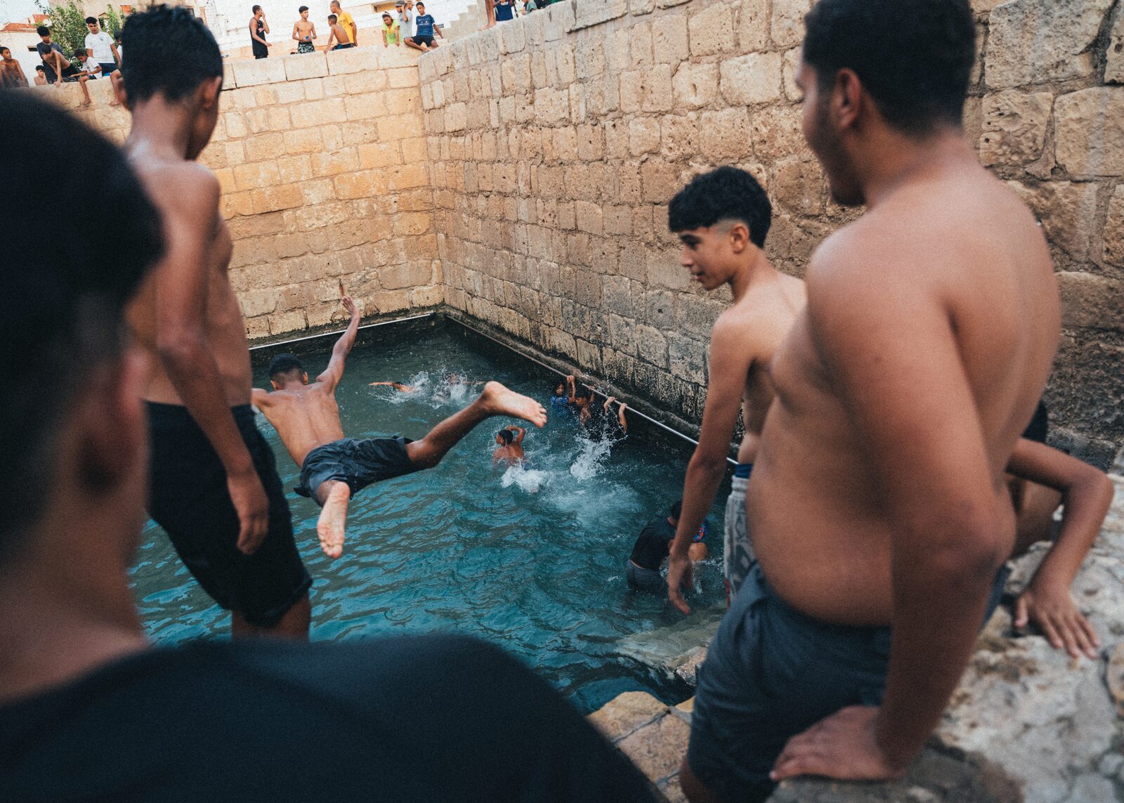 Boys jumping into a stone pool — Zayene Bechir for ZELZAL