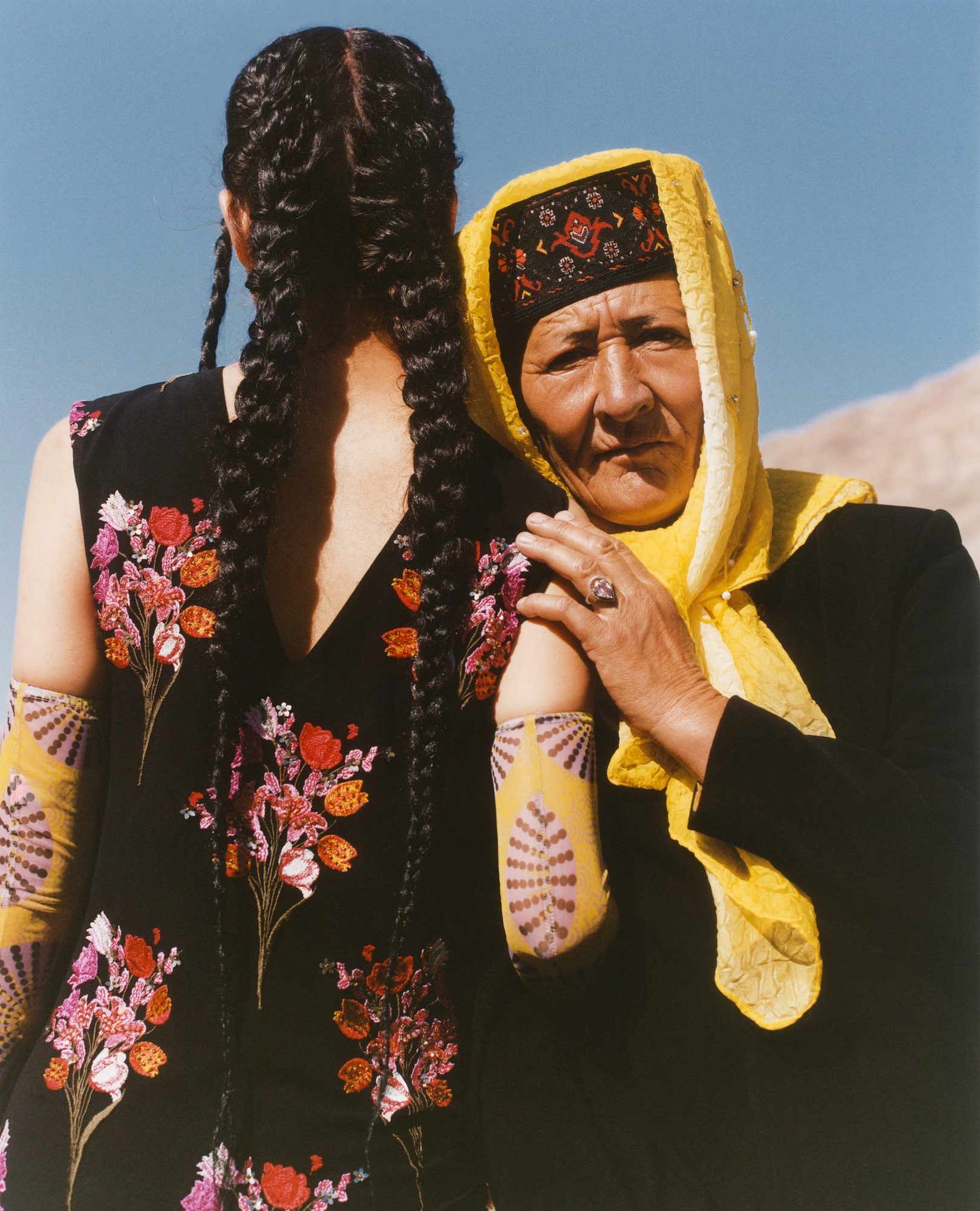TAXKORGAN: bride with braids beside an elder, mountains