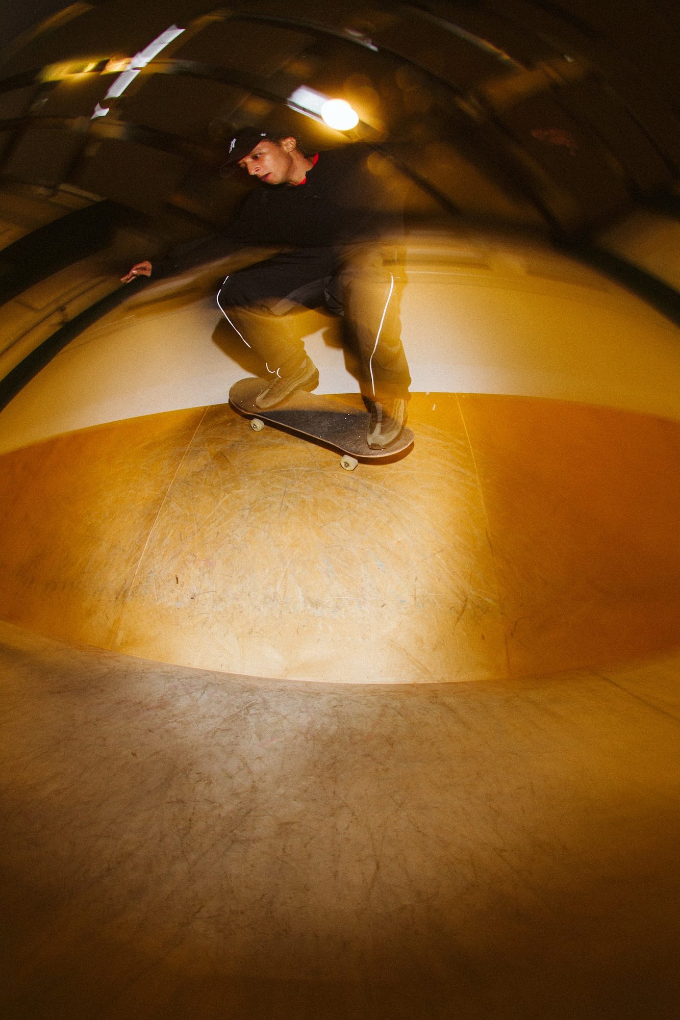 CONCRETE: skater dropping into an amber-lit bowl